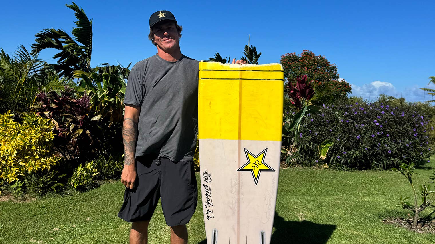 Albee Layer holding his broken yellow SOS big-wave surfboard