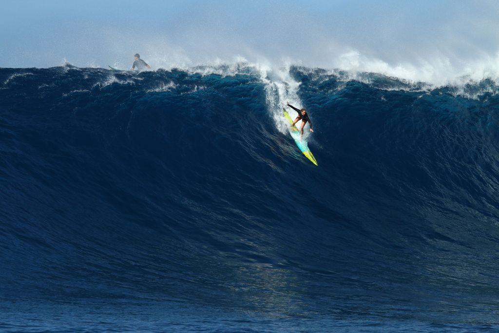 Paige Alms dropping into a massive wave at Peʻahi